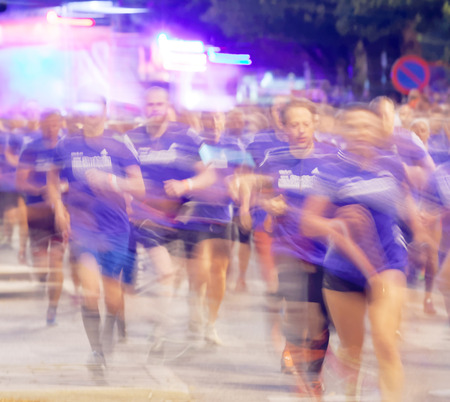 STOCKHOLM, SWEDEN - AUG 15, 2015: Large group of runners in blue dresses with motion blur in the running event Midnattsloppet, August 15, 2015 in Stockholm, Swedenのeditorial素材