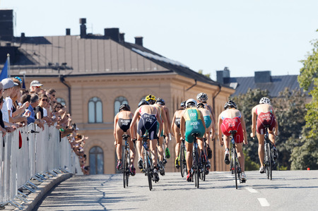 STOCKHOLM - AUG 22, 2015: Rear view of a large group of cyclists in the Women's ITU World Triathlon series event August 22, 2015 in Stockholm, Swedenのeditorial素材