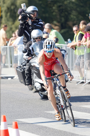 STOCKHOLM - AUG 22, 2015: Triathlete Flora Duffy cycling a curve, followed by the film team in the Women's ITU World Triathlon series event August 22, 2015 in Stockholm, Swedenのeditorial素材