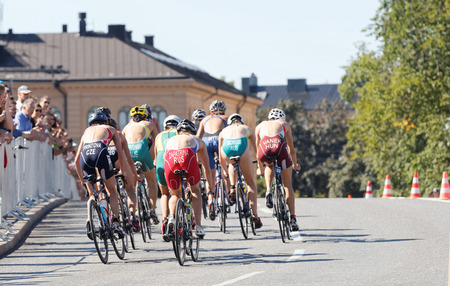 STOCKHOLM - AUG 22, 2015: Rear view of a large group of cyclists in the Women's ITU World Triathlon series event August 22, 2015 in Stockholm, Swedenのeditorial素材