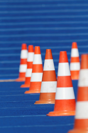 Group of orange cones on blue background, only one in focusの写真素材