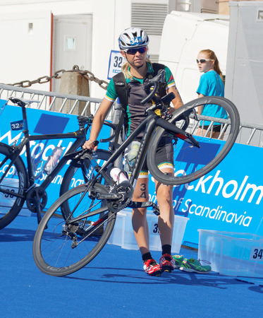 STOCKHOLM - AUG 22, 2015: Emma Jackson lifting her bicycle in the transition zone in the Women's ITU World Triathlon series event August 22, 2015 in Stockholm, Swedenのeditorial素材