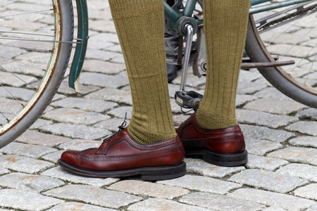 STOCKHOLM - SEPT 19, 2015: Closeup of old fashioned leather shoes, green stockings and bicycle wheels in the Bike in Tweed event September 19, 2015 in Stockholm, Swedenのeditorial素材