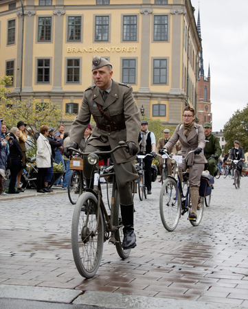 STOCKHOLM - SEPT 19, 2015: Cycling man wearing old fashioned military clothes in the Bike in Tweed event September 19, 2015 in Stockholm, Swedenのeditorial素材