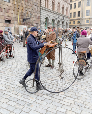 STOCKHOLM - SEPT 19, 2015: Man leading an very old bicycle and wearing old fashioned tweed clothes in the Bike in Tweed event September 19, 2015 in Stockholm, Swedenのeditorial素材