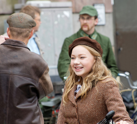 STOCKHOLM - SEPT 19, 2015: Young smiling girl wearing old fashioned tweed clothes in the Bike in Tweed event September 19, 2015 in Stockholm, Swedenのeditorial素材