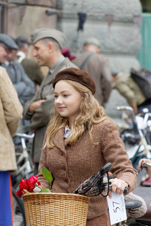 STOCKHOLM - SEPT 19, 2015: Blonde beautiful girl in a group of people wearing old fashioned tweed clothes and bikes in the Bike in Tweed event September 19, 2015 in Stockholm, Swedenのeditorial素材