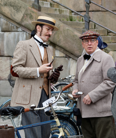 STOCKHOLM - SEPT 19, 2015: Two elegant men wearing old fashioned clothes, trilby hat and smoking a pipe in the Bike in Tweed event September 19, 2015 in Stockholm, Swedenのeditorial素材