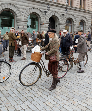 STOCKHOLM - SEPT 19, 2015: Elegant woman leading her cycle, wearing old fashioned tweed clothes in the Bike in Tweed event September 19, 2015 in Stockholm, Swedenのeditorial素材