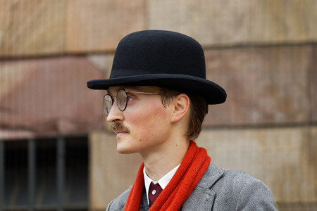 STOCKHOLM - SEPT 19, 2015: Side view of young man with mustache wearing old fashioned tweed clothes, hat and glasses in the Bike in Tweed event September 19, 2015 in Stockholm, Swedenのeditorial素材