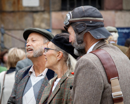 STOCKHOLM - SEPT 19, 2015: Elegant lady surrounded by two older men with beard wearing tweed in the...