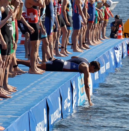 STOCKHOLM - AUG 22, 2015: Group of male swimming competitors in colorful swimsuits waiting for the start signal in the Mens's ITU World Triathlon series event August 22, 2015 in Stockholm, Swedenのeditorial素材