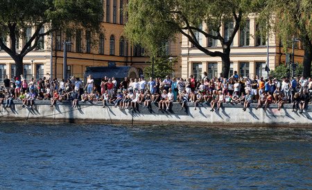 STOCKHOLM - AUG 22, 2015: Audience sitting on the quay in Stockholm during  the Men's ITU World Triathlon series event August 22, 2015 in Stockholm, Swedenのeditorial素材