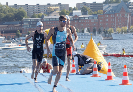 STOCKHOLM - AUG 22, 2015: Group of male swimmers climbing up from the water in the Men's ITU World Triathlon series event August 22, 2015 in Stockholm, Swedenのeditorial素材