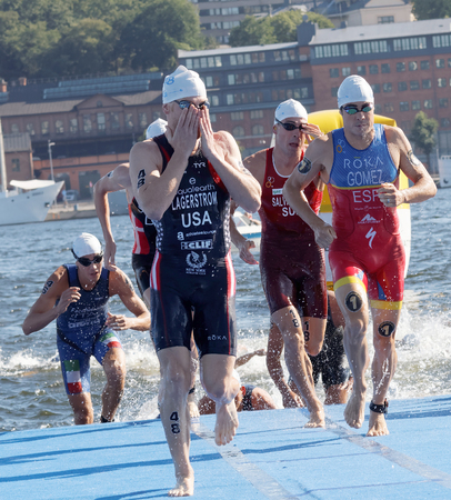 STOCKHOLM - AUG 22, 2015: Mario Mola, Eric Lagerstrom and other male swimmers climbing up from the water in the Men's ITU World Triathlon series event August 22, 2015 in Stockholm, Swedenのeditorial素材