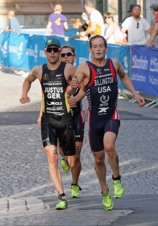 STOCKHOLM, SWEDEN - AUG 23, 2015: Tough fight between three running triathletes, Gregory Billington in the lead in the sunshine in the Men's ITU World Triathlon series event August 23, 2015 in Stockholm, Swedenのeditorial素材