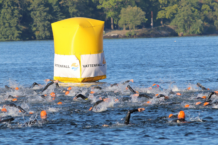 STOCKHOLM - AUG 23, 2015: Swimming chaos of crawling male swimmers wearing orange bathing caps  at ITU World Triathlon event in Stockholm, 2015のeditorial素材