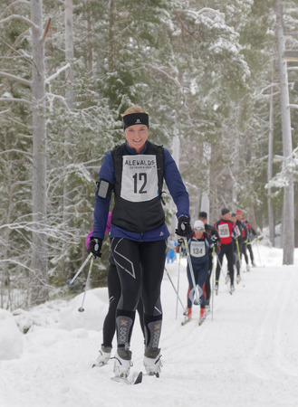 STOCKHOLM - JAN 24, 2016: Smiling cross country skiing woman and competitors in the forest at the Stockholm Ski Marathon event January 24, 2016 in Stockholm, Swedenのeditorial素材