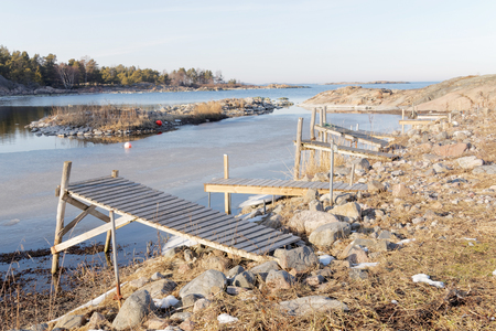 Many small rural wooden bridges and ice a beautiful spring / winter day in the archipelagoの写真素材