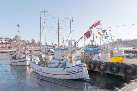 Fishing boats boat in the small harbor during springtime. Some ice left and sunshine.の写真素材