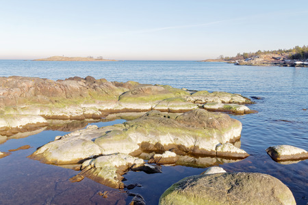 Archipelago, sea and rocks covered with green algae a sunny morning in spring in Swedenの写真素材