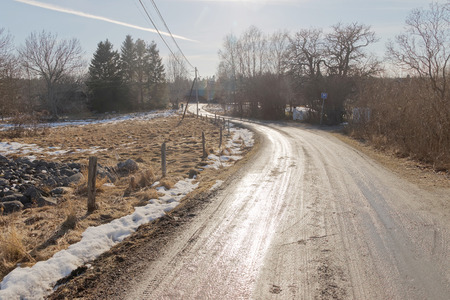 Old curved country road in the swedish countryside a sunny day during spring timeの写真素材