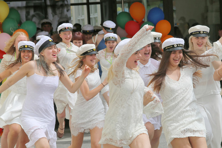 STOCKHOLM, SWEDEN - JUN 10, 2015: Group of happy teenage girls wearing graduation caps running out from school after graduation from high school at the school Globala gymnasiet, June 10, 2015, Stockholm, Swedenのeditorial素材