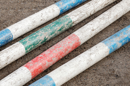 Colorful bars from horse jumping obstacles laying on the groundの写真素材