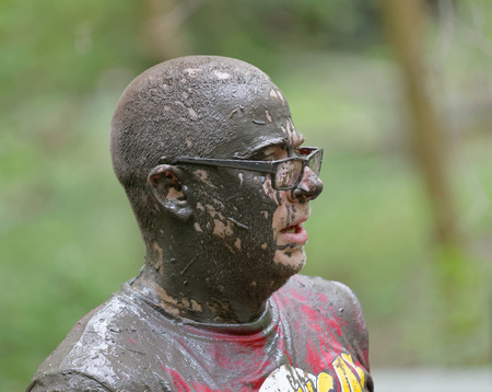 STOCKHOLM, SWEDEN - MAY 14, 2016: Man wearing glasses covered with mud in the obstacle race Tough...