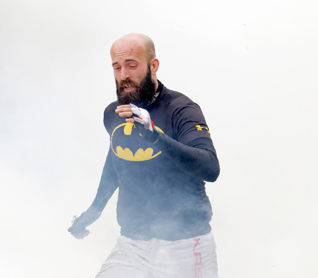 STOCKHOLM, SWEDEN - MAY 14, 2016: Balled man with beard running through fire and smoke in the...