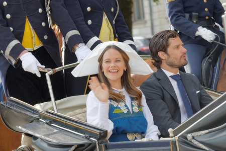 STOCKHOLM, SWEDEN - JUN 06, 2016: The swedish princess and prince Sofia and Carl Philip Bernadotte smiling and waiving to the audience from the royal coach on their way to celebrate the swedish national day.のeditorial素材