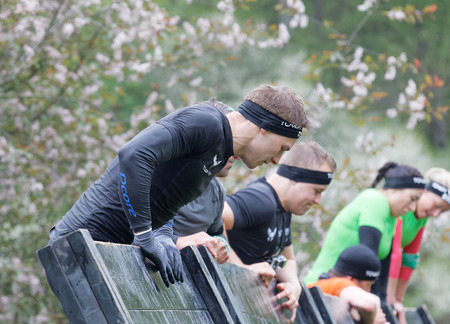 STOCKHOLM, SWEDEN - MAY 14, 2016: Men climbing over a plank obstracle in the obstacle race Tough Viking Event in Sweden, May 14, 2016のeditorial素材