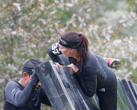 STOCKHOLM, SWEDEN - MAY 14, 2016: Women climbing over a plank obstracle in the obstacle race Tough Viking Event in Sweden, May 14, 2016のeditorial素材