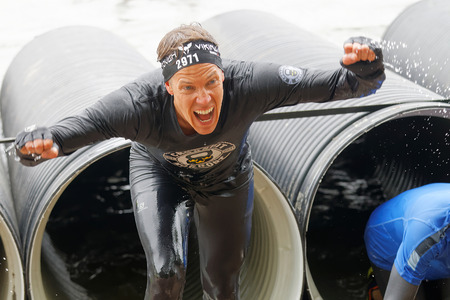 STOCKHOLM, SWEDEN - MAY 14, 2016: Screaming man coming out from a tube obstacle in the obstacle race Tough Viking Event in Sweden, May 14, 2016のeditorial素材