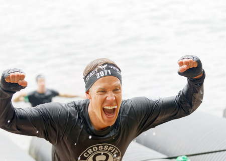 STOCKHOLM, SWEDEN - MAY 14, 2016: Screaming man coming out from a tube obstacle in the obstacle race Tough Viking Event in Sweden, May 14, 2016のeditorial素材