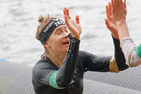 STOCKHOLM, SWEDEN - MAY 14, 2016: Smiling woman making a high five in the obstacle race Tough Viking Event in Sweden, May 14, 2016のeditorial素材