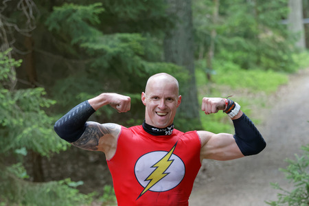 STOCKHOLM, SWEDEN - MAY 14, 2016: Strong smiling man dressed as a super hero showing his muscles in the obstacle race Tough Viking Event in Sweden, May 14, 2016のeditorial素材