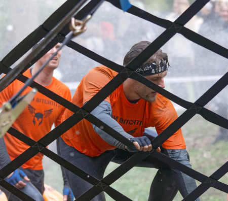 STOCKHOLM, SWEDEN - MAY 14, 2016: Men climbing a net obstacle in the obstacle race Tough Viking Event in Sweden, May 14, 2016のeditorial素材