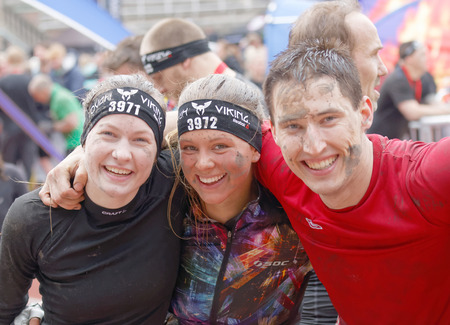 STOCKHOLM, SWEDEN - MAY 14, 2016: Two smiling woman and a man with mud in the face after finishing a race in the obstacle race Tough Viking Event in Sweden, May 14, 2016のeditorial素材