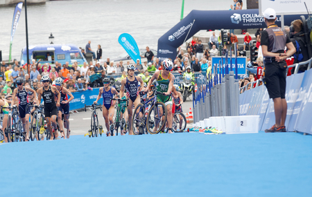 STOCKHOLM - JUL 02, 2016: Group of triathletes running with cycles in the transition zone in the Women's ITU World Triathlon series event July 02, 2016 in Stockholm, Swedenのeditorial素材