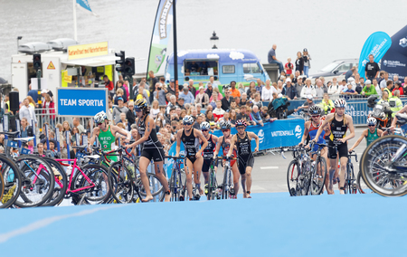 STOCKHOLM - JUL 02, 2016: Group of triathletes running with cycles in the transition zone in the Women's ITU World Triathlon series event July 02, 2016 in Stockholm, Swedenのeditorial素材