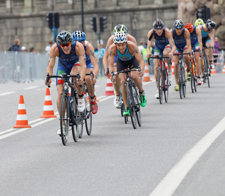STOCKHOLM, SWEDEN - JUL 02, 2016: Group of colorful male triathlete cyclists, Gregory Barnaby (ITA), and competitors in the Men's ITU World Triathlon series event July 02, 2016 in Stockholm, Swedenのeditorial素材