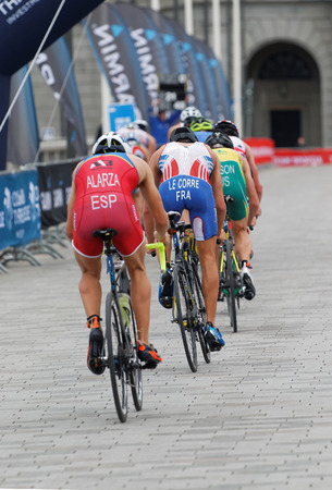 STOCKHOLM, SWEDEN - JUL 02, 2016: Rear view of a group of male triathlete cyclists, Alarza (ESP), Le Corre (FRA) and competitors in the Men's ITU World Triathlon series event July 02, 2016 in Stockholm, Swedenのeditorial素材