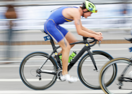 STOCKHOLM, SWEDEN - JUL 02, 2016: Side view of male triathlete cyclist Gabriel Sandor (SWE), slightly blureed, in the Men's ITU World Triathlon series event July 02, 2016 in Stockholm, Swedenのeditorial素材