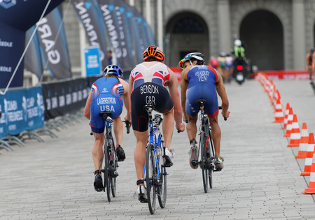 STOCKHOLM, SWEDEN - JUL 02, 2016: Rear view of a group of male triathlete cyclists, Gordon Benson (GBR), Eric Lagerstrom (USA), Velasques (VEN) and competitors in the Men's ITU World Triathlon series event July 02, 2016 in Stockholm, Swedenのeditorial素材