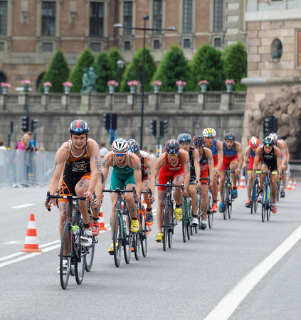STOCKHOLM, SWEDEN - JUL 02, 2016: Group of colorful male triathlete cyclists, Menno Koolhaase (NED), and competitors in the Men's ITU World Triathlon series event July 02, 2016 in Stockholm, Swedenのeditorial素材