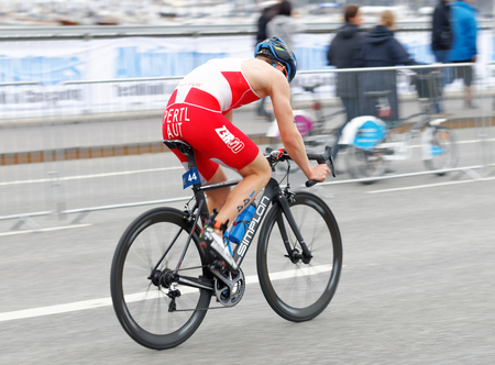 STOCKHOLM, SWEDEN - JUL 02, 2016: Side view of male triathlete cyclist Lukas Pertl (AUT) in the Men's ITU World Triathlon series event July 02, 2016 in Stockholm, Swedenのeditorial素材