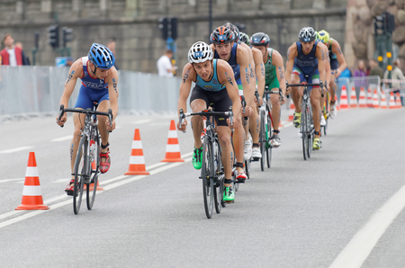 STOCKHOLM, SWEDEN - JUL 02, 2016: Group of colorful male triathlete cyclists, Jelle Geens (BEL), and competitors in the Men's ITU World Triathlon series event July 02, 2016 in Stockholm, Swedenのeditorial素材