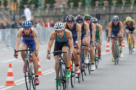 STOCKHOLM, SWEDEN - JUL 02, 2016: Group of colorful male triathlete cyclists, Jelle Geens (BEL), and competitors in the Men's ITU World Triathlon series event July 02, 2016 in Stockholm, Swedenのeditorial素材