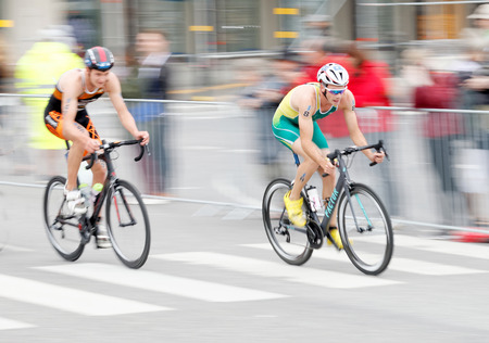 STOCKHOLM, SWEDEN - JUL 02, 2016: Side view of  two male triathlete cyclist Jacob Birthwistle (AUS), slightly blureed, in the Men's ITU World Triathlon series event July 02, 2016 in Stockholm, Swedenのeditorial素材